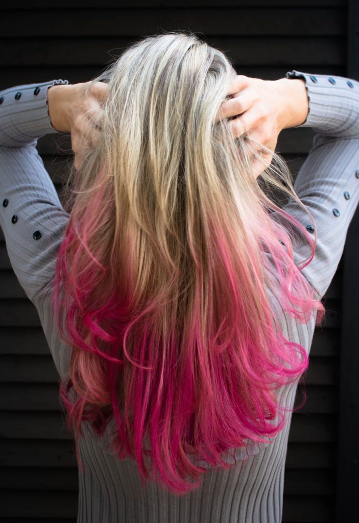 woman in gray long sleeved top holding hair