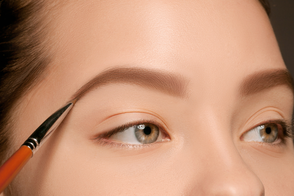 beautiful female eyes with make up brush Choosing the Right Tools for Natural Brow Grooming